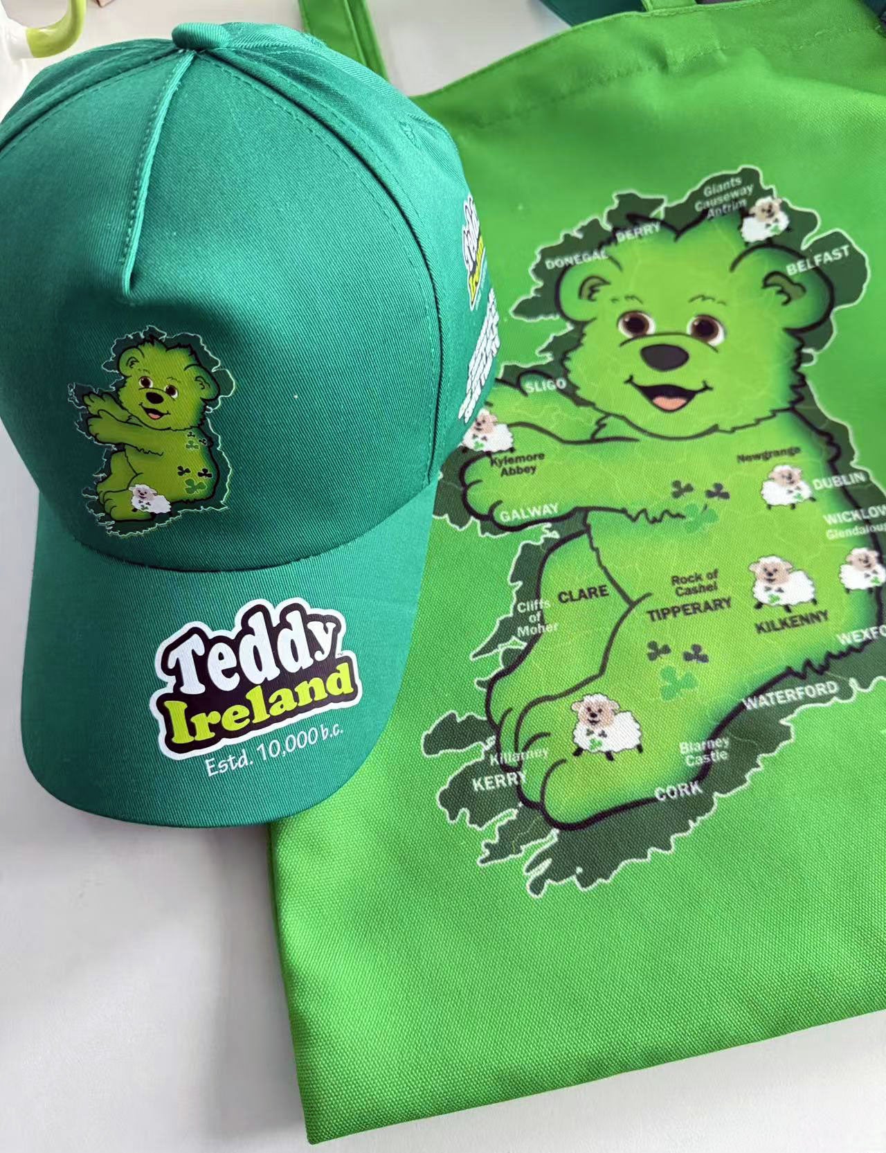 Green cap and tote bag with teddy bear design and 'Teddy Ireland' branding on a white background