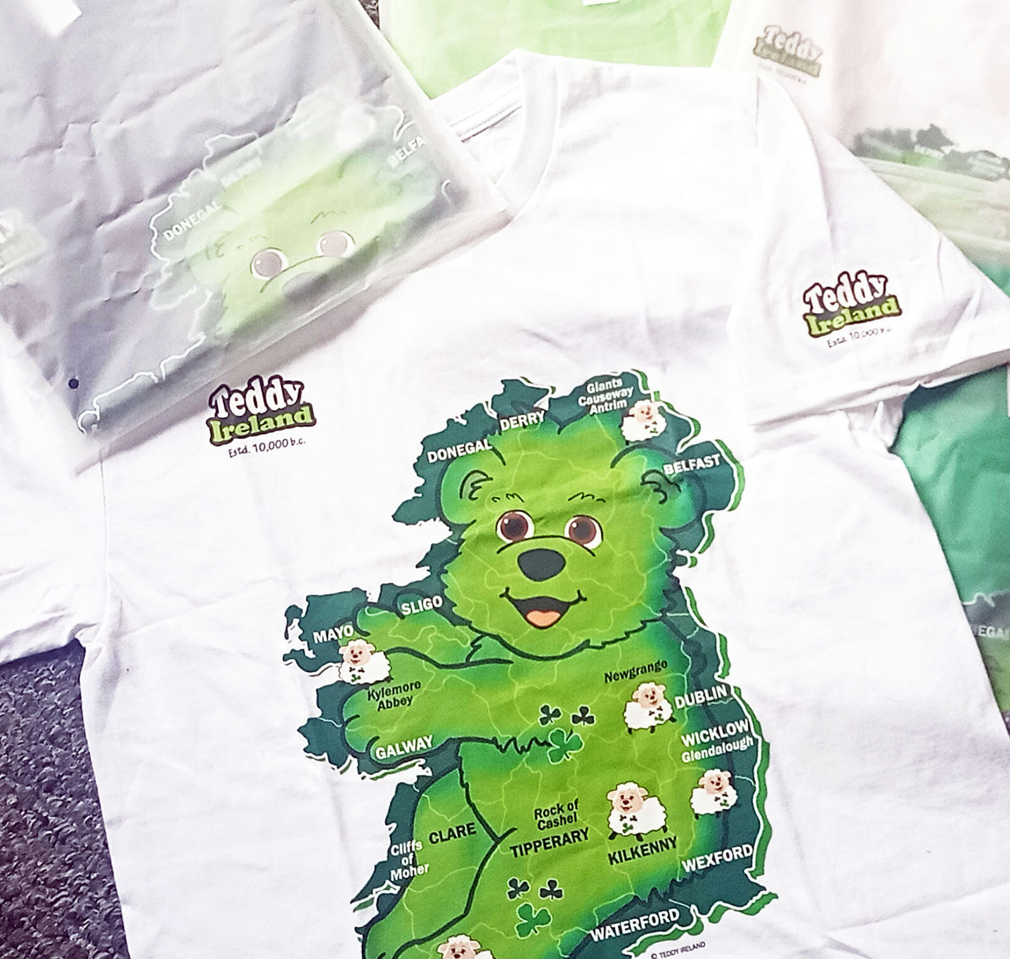 White t-shirt with a green bear-shaped map of Ireland and 'Teddy Ireland' branding.