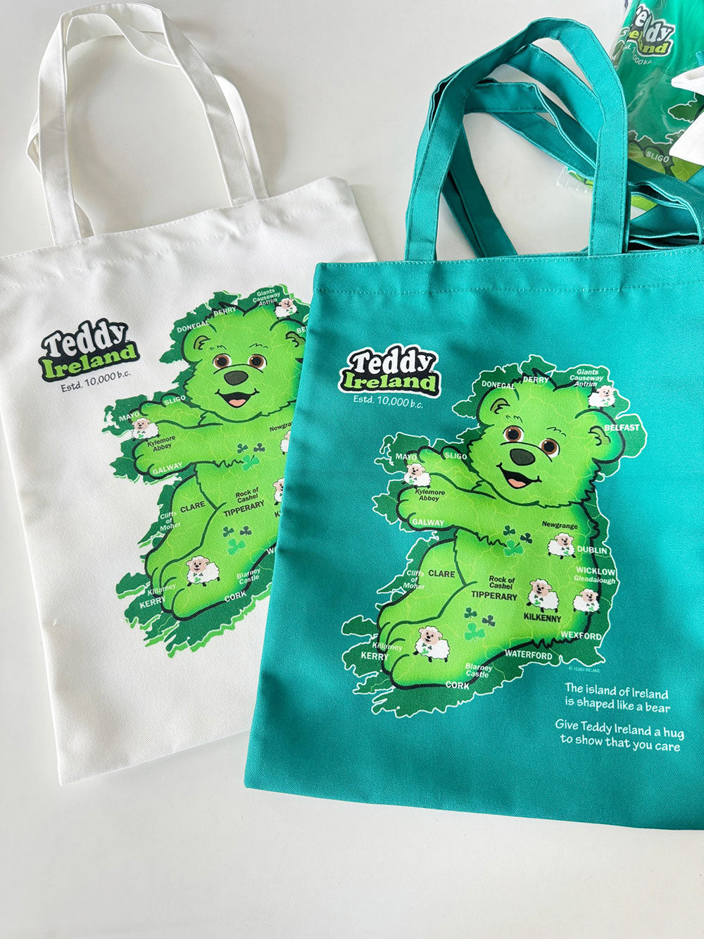 Two tote bags with a green bear illustration and 'Teddy Ireland' text on a white background.